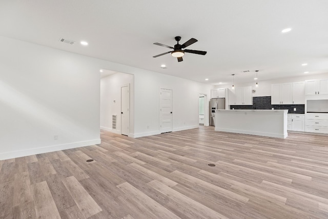 unfurnished living room with ceiling fan and light wood-type flooring