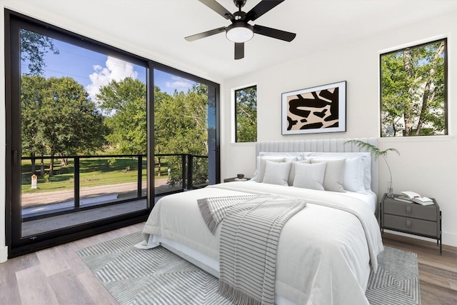 bedroom with multiple windows, ceiling fan, access to outside, and light hardwood / wood-style floors