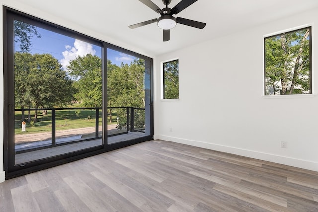 unfurnished room featuring ceiling fan, a healthy amount of sunlight, and light wood-type flooring