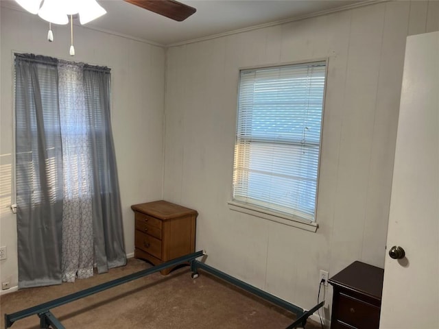 carpeted bedroom featuring crown molding and ceiling fan