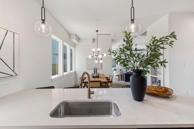 kitchen with light countertops, a sink, and decorative light fixtures