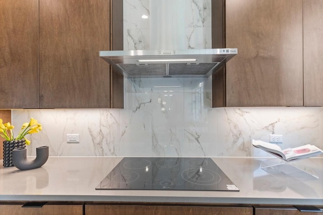 room details with brown cabinets, backsplash, ventilation hood, and black electric cooktop