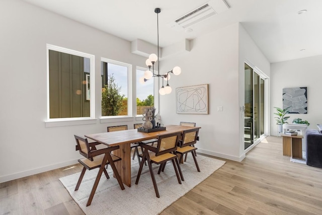 dining area featuring light wood-style floors, visible vents, and baseboards