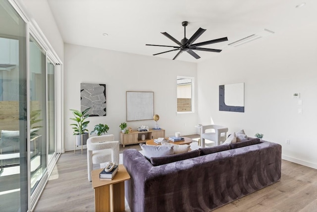 living room with light wood finished floors, baseboards, and a ceiling fan