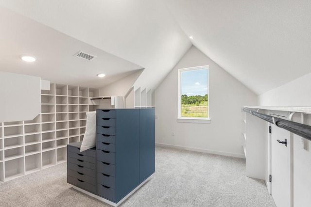 walk in closet featuring vaulted ceiling, visible vents, and light colored carpet