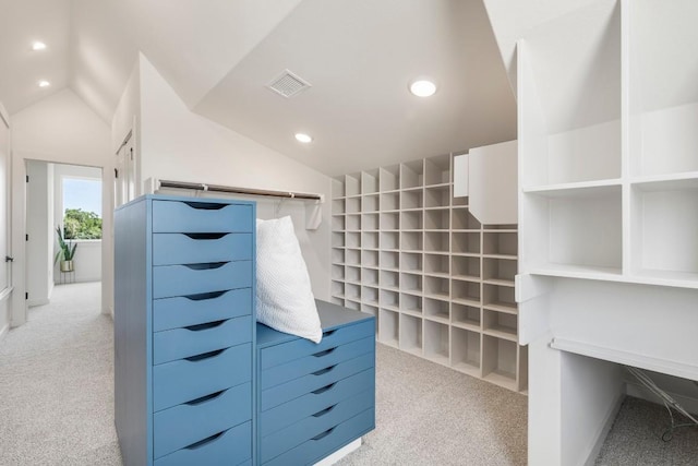 spacious closet with light carpet, vaulted ceiling, and visible vents