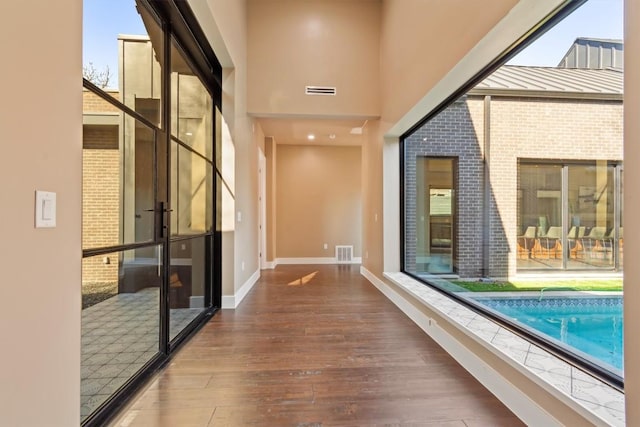 hallway featuring wood-type flooring and a high ceiling