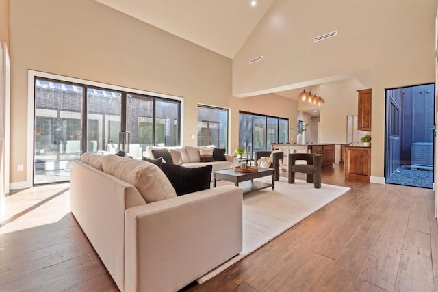 living room with high vaulted ceiling and light hardwood / wood-style floors