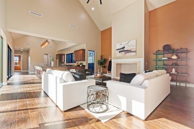 living room with wood-type flooring and high vaulted ceiling