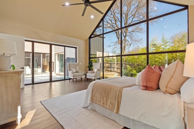 bedroom with high vaulted ceiling, access to exterior, and light wood-type flooring