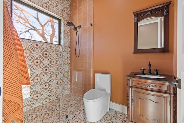 bathroom featuring vanity, tiled shower, tile patterned floors, and toilet