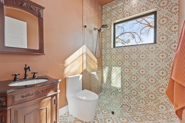 bathroom featuring vanity, toilet, and tiled shower