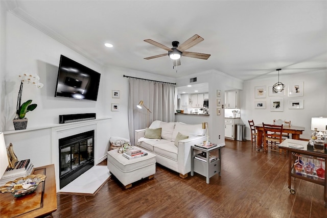 living room featuring ceiling fan, ornamental molding, and dark hardwood / wood-style flooring