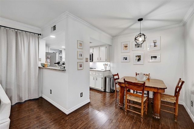 dining room with dark wood-type flooring and crown molding