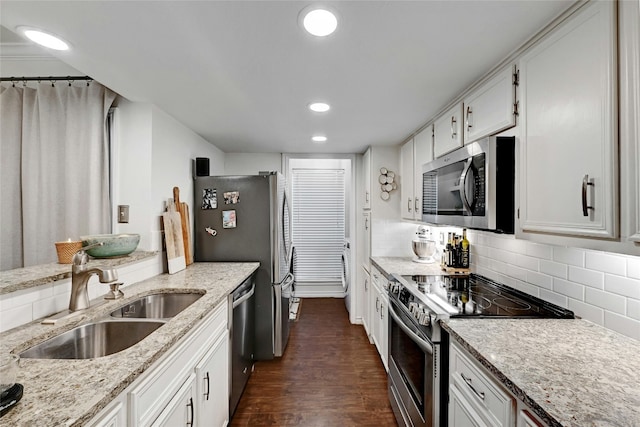 kitchen featuring dark wood-type flooring, sink, tasteful backsplash, stainless steel appliances, and white cabinets