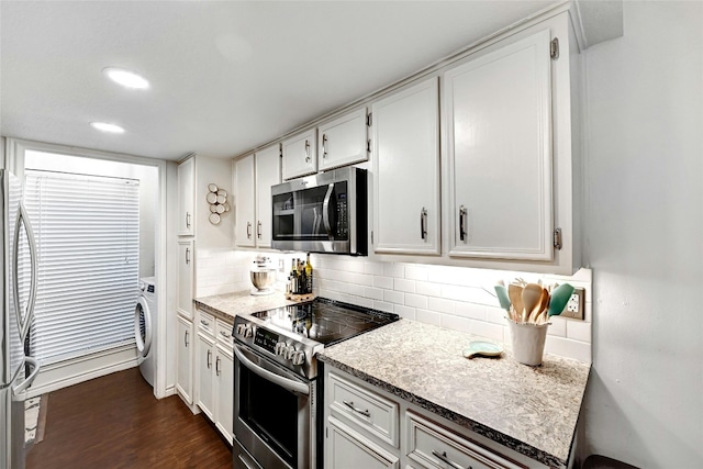 kitchen featuring washer / dryer, white cabinetry, appliances with stainless steel finishes, and backsplash