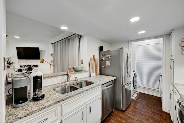 kitchen featuring appliances with stainless steel finishes, sink, white cabinets, and light stone counters