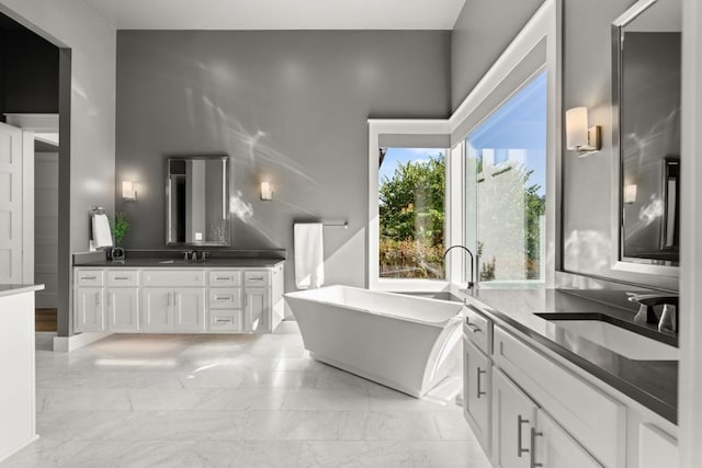 821 Laughing Dog Ct, Leander, TX 78641 - bathroom with two vanities, a freestanding bath, and marble finish flooring