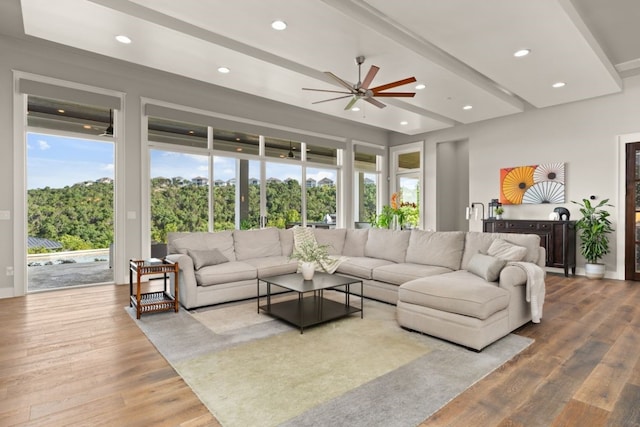 living room featuring beam ceiling, wood-type flooring, and ceiling fan