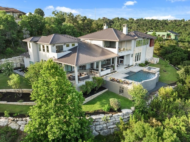 rear view of house with a balcony, a yard, and a patio area