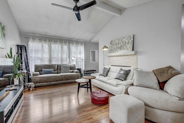 living room featuring hardwood / wood-style flooring, ceiling fan, high vaulted ceiling, a textured ceiling, and beamed ceiling