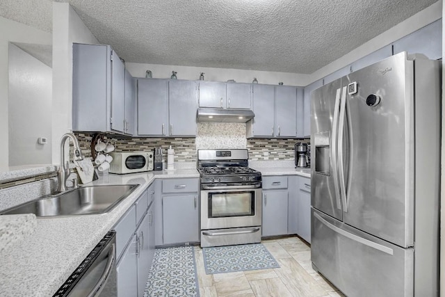 kitchen featuring tasteful backsplash, appliances with stainless steel finishes, sink, and gray cabinets