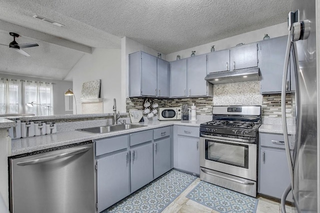 kitchen featuring sink, ceiling fan, appliances with stainless steel finishes, backsplash, and vaulted ceiling with beams