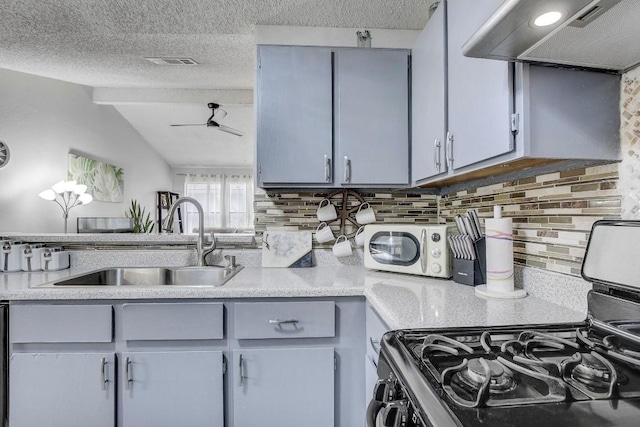 kitchen featuring sink, gas range, a textured ceiling, decorative backsplash, and exhaust hood