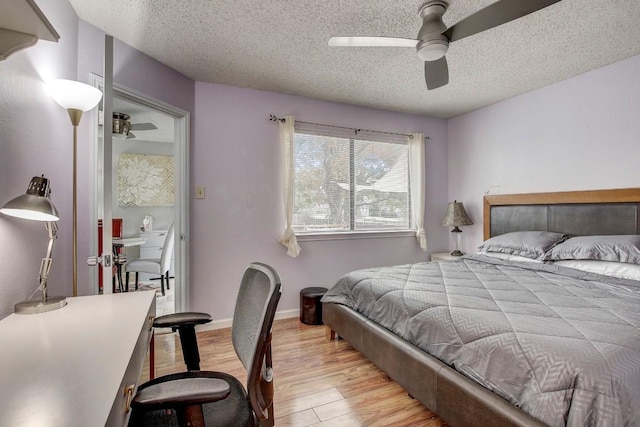 bedroom featuring ceiling fan, a textured ceiling, and light wood-type flooring