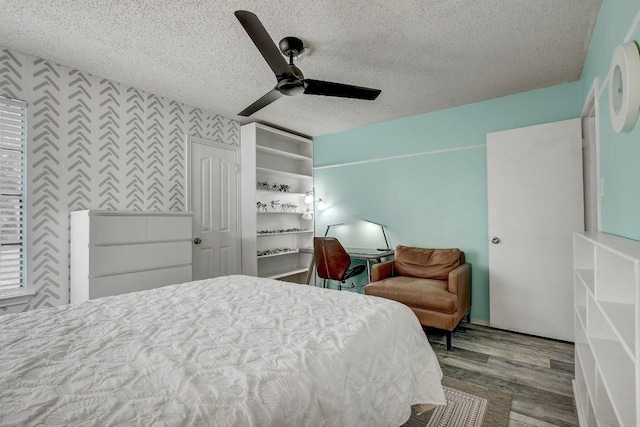 bedroom featuring hardwood / wood-style flooring, ceiling fan, and a textured ceiling