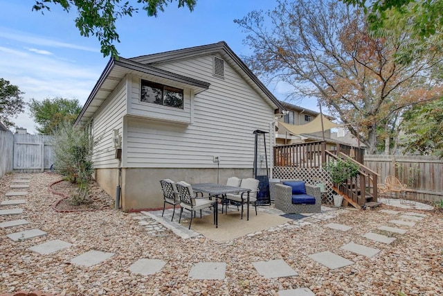 rear view of property with a deck and a patio area