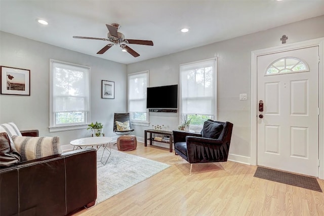 living room featuring ceiling fan and light hardwood / wood-style floors