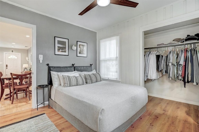 bedroom with crown molding, a closet, ceiling fan, and light wood-type flooring