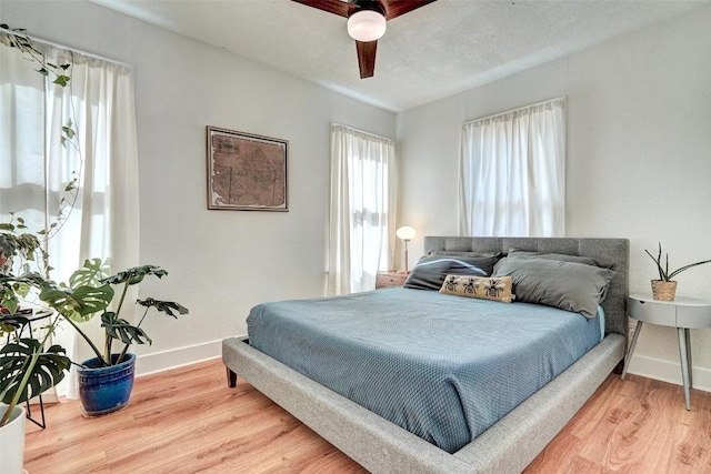 bedroom with ceiling fan and light hardwood / wood-style flooring