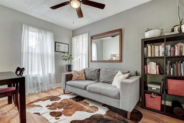 living room with hardwood / wood-style flooring and ceiling fan