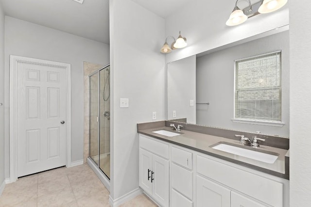 bathroom with a shower stall, double vanity, tile patterned floors, and a sink