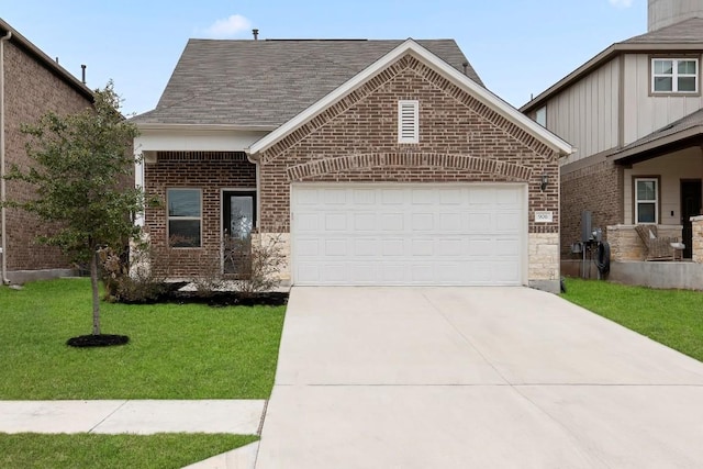 view of front of home with a front yard, driveway, an attached garage, a shingled roof, and brick siding