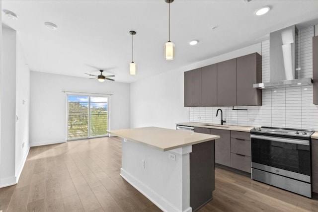 kitchen with sink, tasteful backsplash, a kitchen island, stainless steel electric stove, and wall chimney exhaust hood