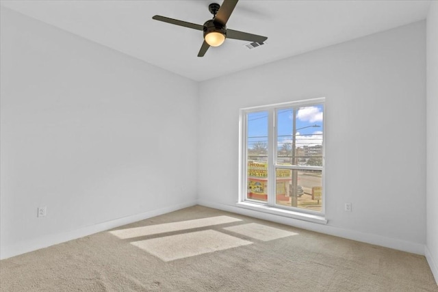 carpeted spare room featuring ceiling fan