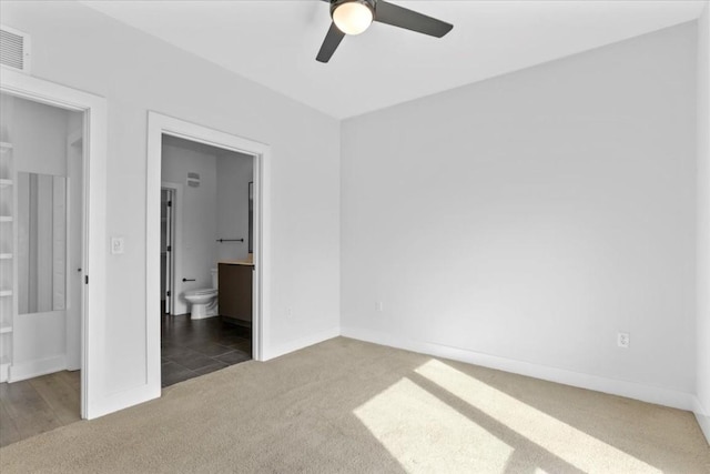 unfurnished bedroom with ensuite bathroom, carpet flooring, and ceiling fan