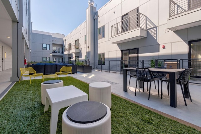 view of property's community featuring a yard and a patio area