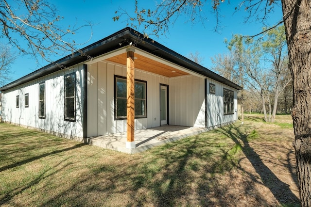 back of property with a patio area and a lawn