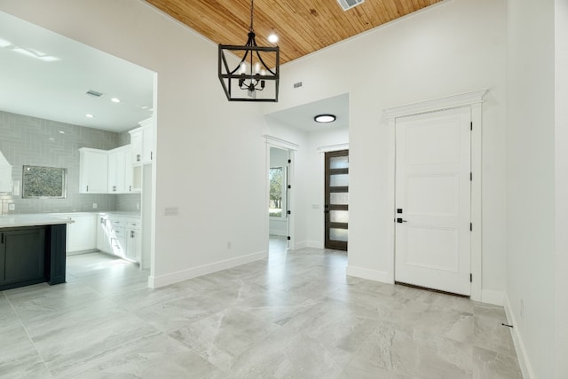 interior space featuring wood ceiling, a towering ceiling, and a chandelier