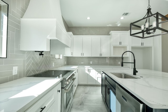 kitchen with sink, light stone counters, pendant lighting, stainless steel appliances, and white cabinets