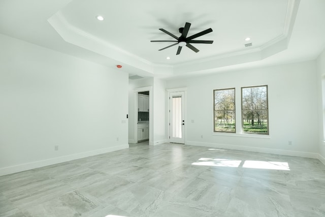 unfurnished room with a raised ceiling, ornamental molding, and ceiling fan