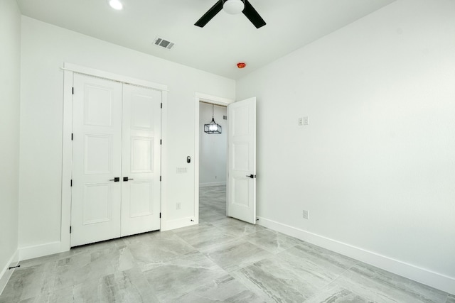 unfurnished bedroom featuring ceiling fan and a closet