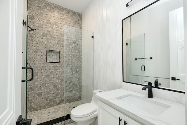 bathroom featuring vanity, toilet, and a shower with shower door