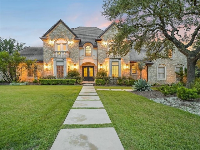 3844 Hunterwood Pt, Austin, TX 78746 - french country inspired facade with stone siding, french doors, a lawn, and a high end roof
