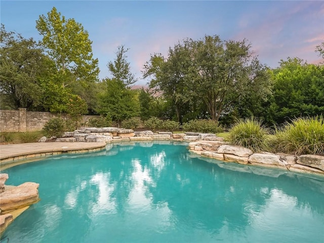 view of pool at dusk