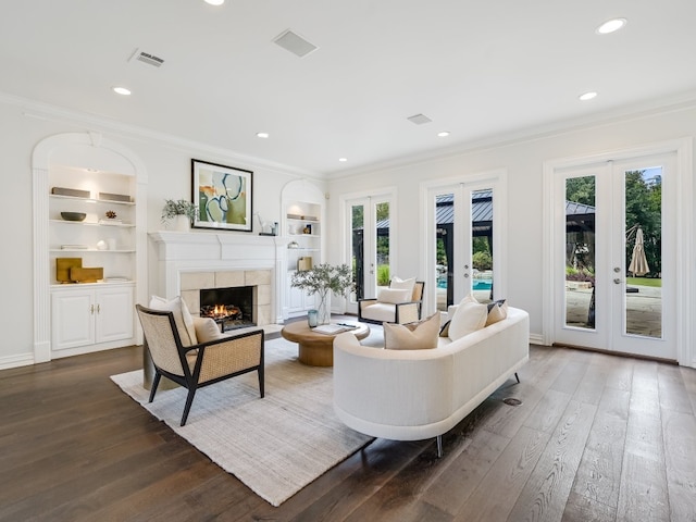 living room featuring crown molding, built in features, and french doors